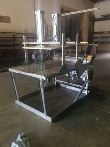 Industrial machine with metal frame and mechanical parts in a workshop.