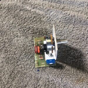 A small electronic circuit with a rotary switch on a carpet.