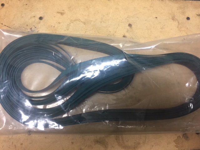 A coiled black cable inside a plastic bag on a wooden surface.
