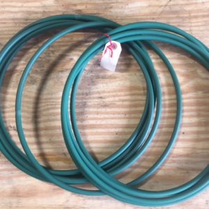 Two green rubber O-rings on a wooden surface.