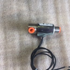 A small electronic device with a cable and an orange connector.