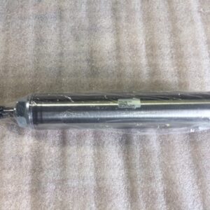 A metallic cylindrical object lying on a textured surface.