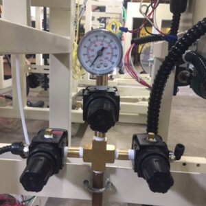 Pressure gauge and valves on industrial piping system.