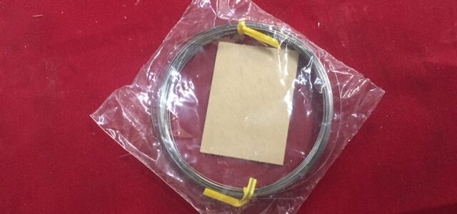 A packaged cable with yellow connectors on a red surface.