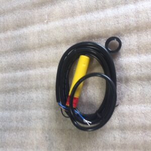 Coiled black cable with a yellow connector on a fabric background.