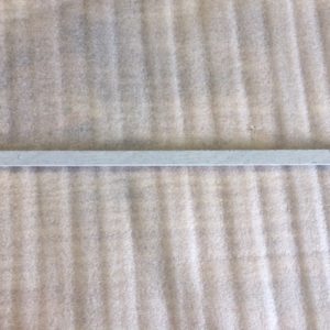 A close-up of a corrugated metal sheet with a horizontal support beam.