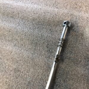 Close-up of a metal telescopic rod on carpet.