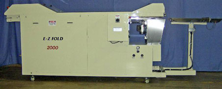 Industrial machine with control panel and components on a factory floor.